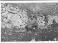 A soldier squats next to a mortar shell in Italy. [Courtesy of Mary Hamasaki]